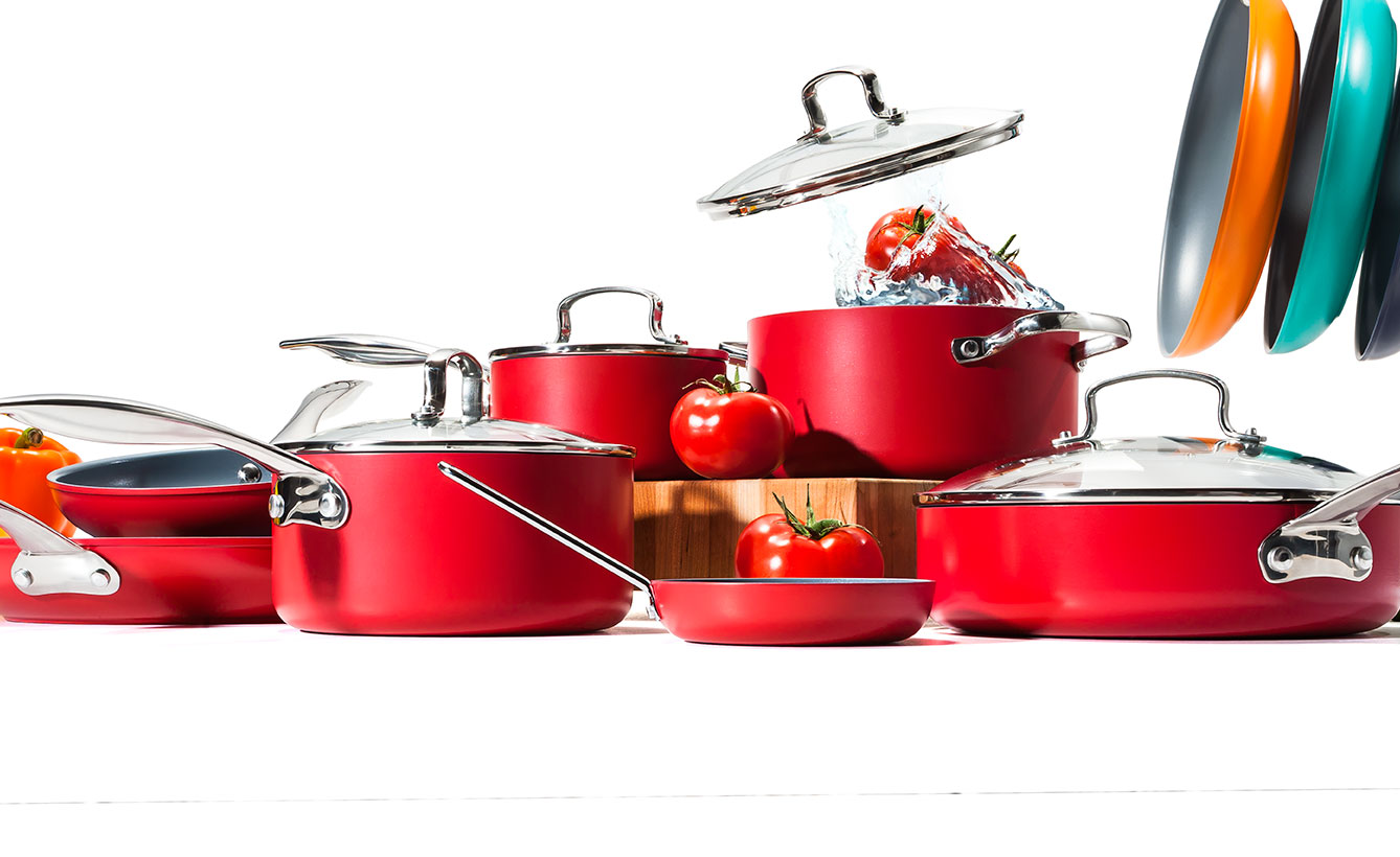 Red kitchenware with splashing tomatoes 