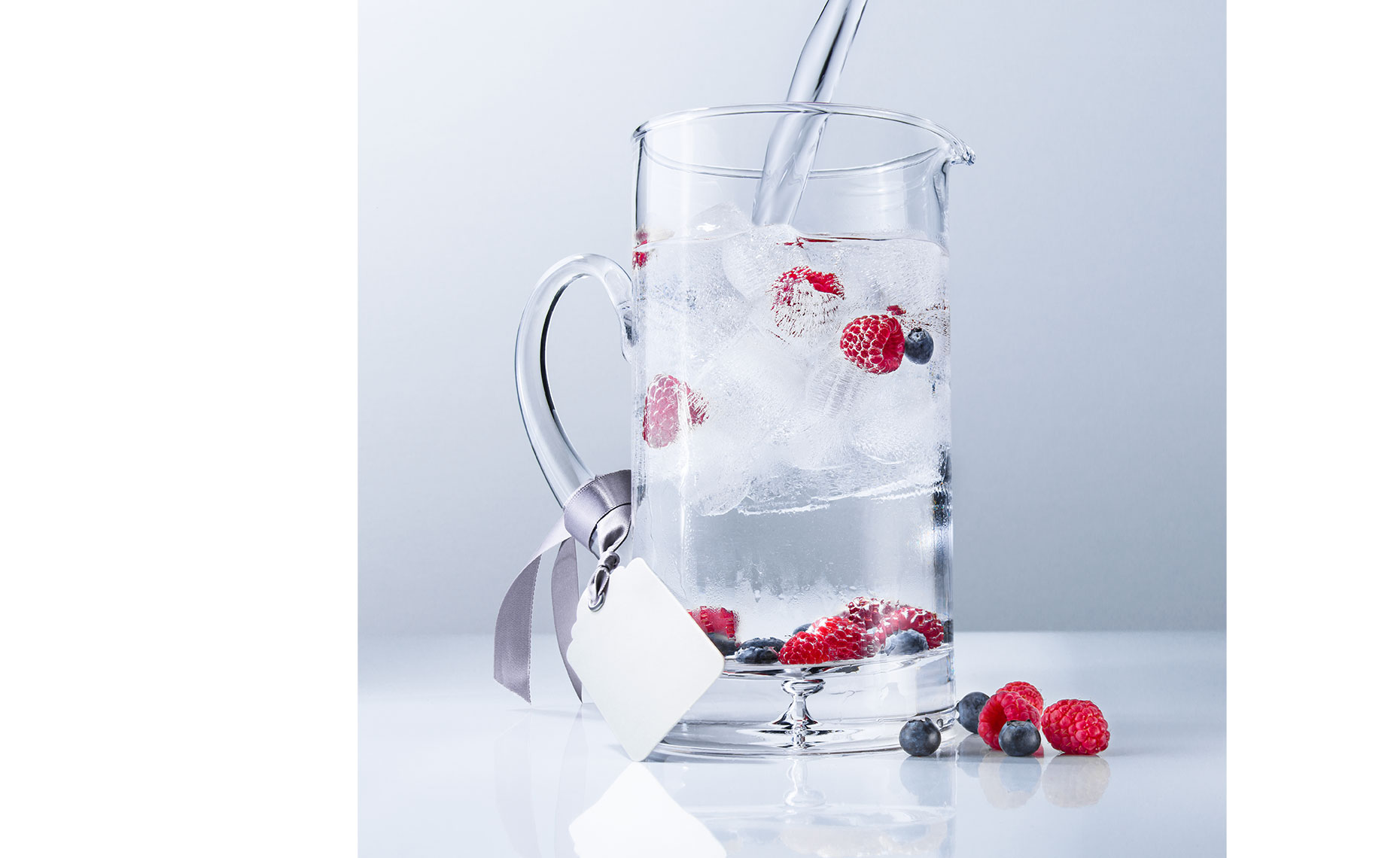 Chilled pitcher with water pour and raspberries
